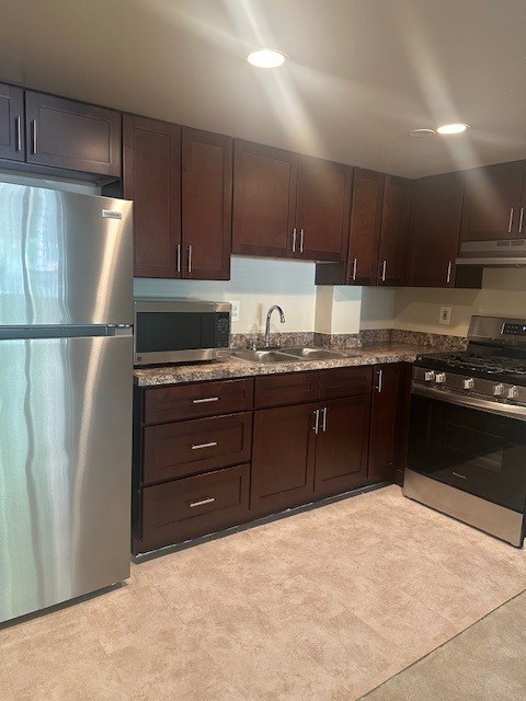 A kitchen with brown cabinets and a stainless steel refrigerator. at 2400 Pennsylvania Avenue Apartments, Washington